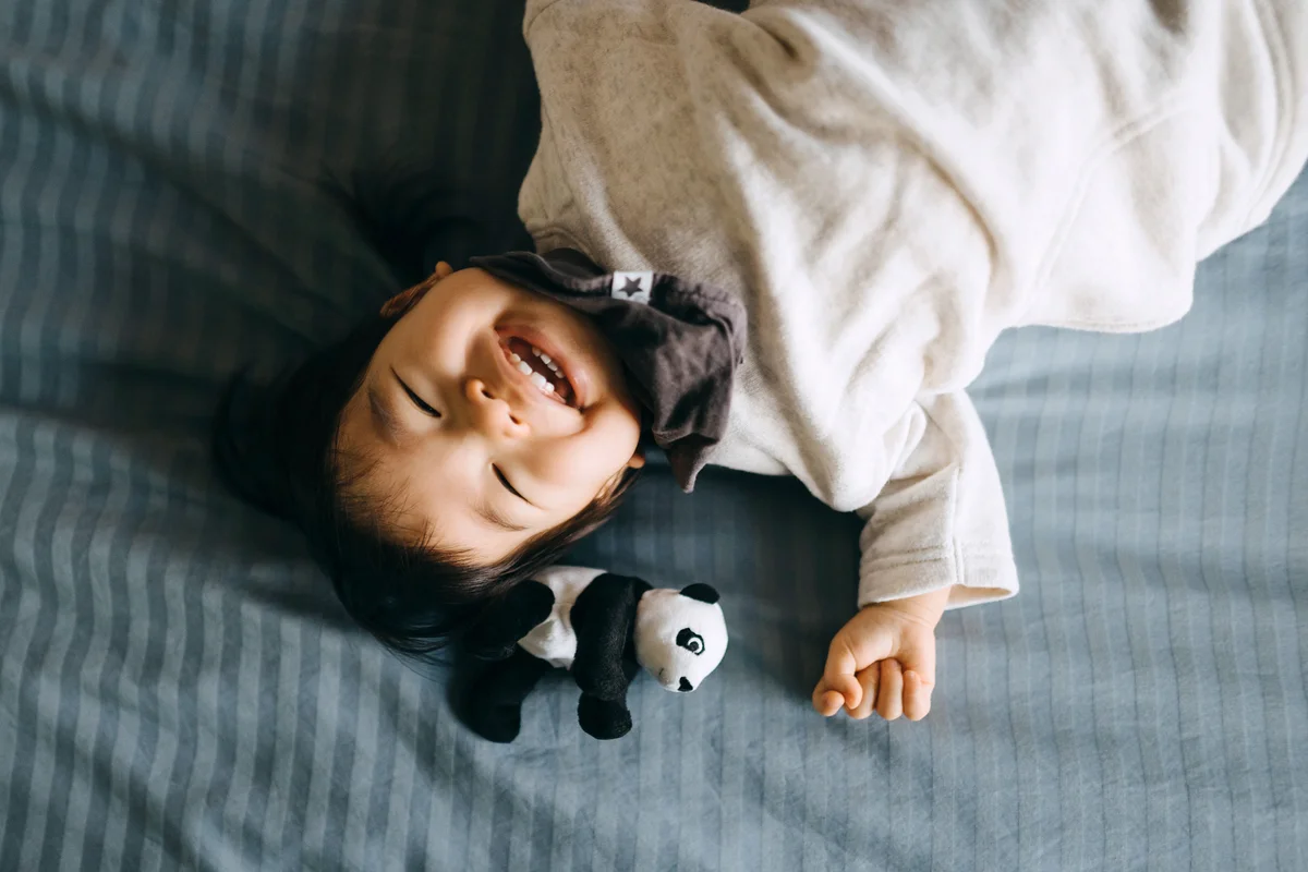 Asian toddler girl laughing joyfully