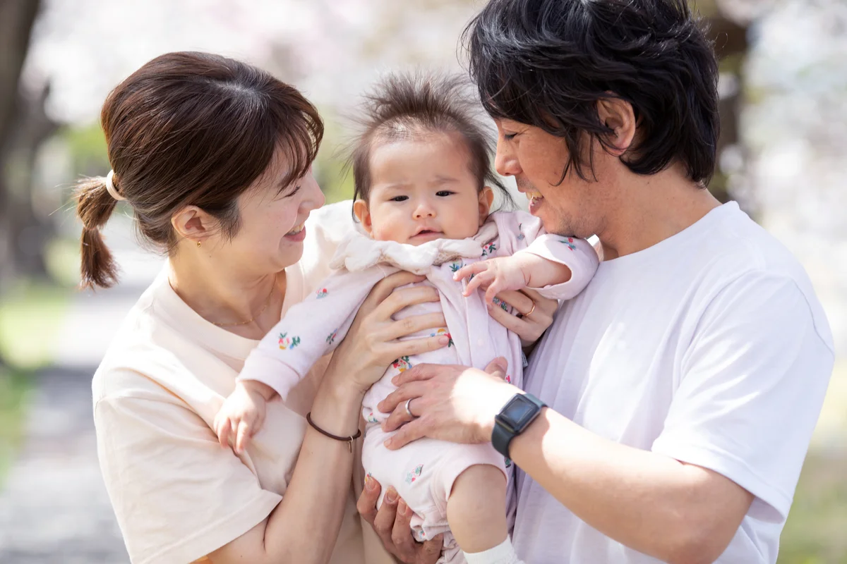 Young family with baby girl and Cherry blossoms