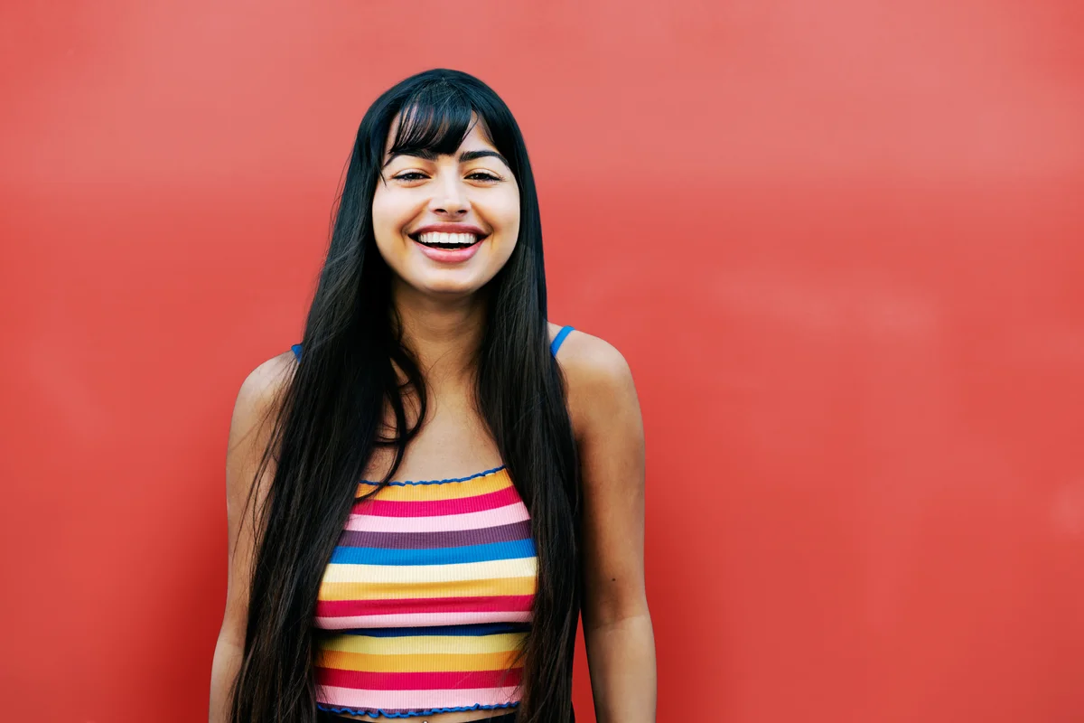 woman standing against a red wall