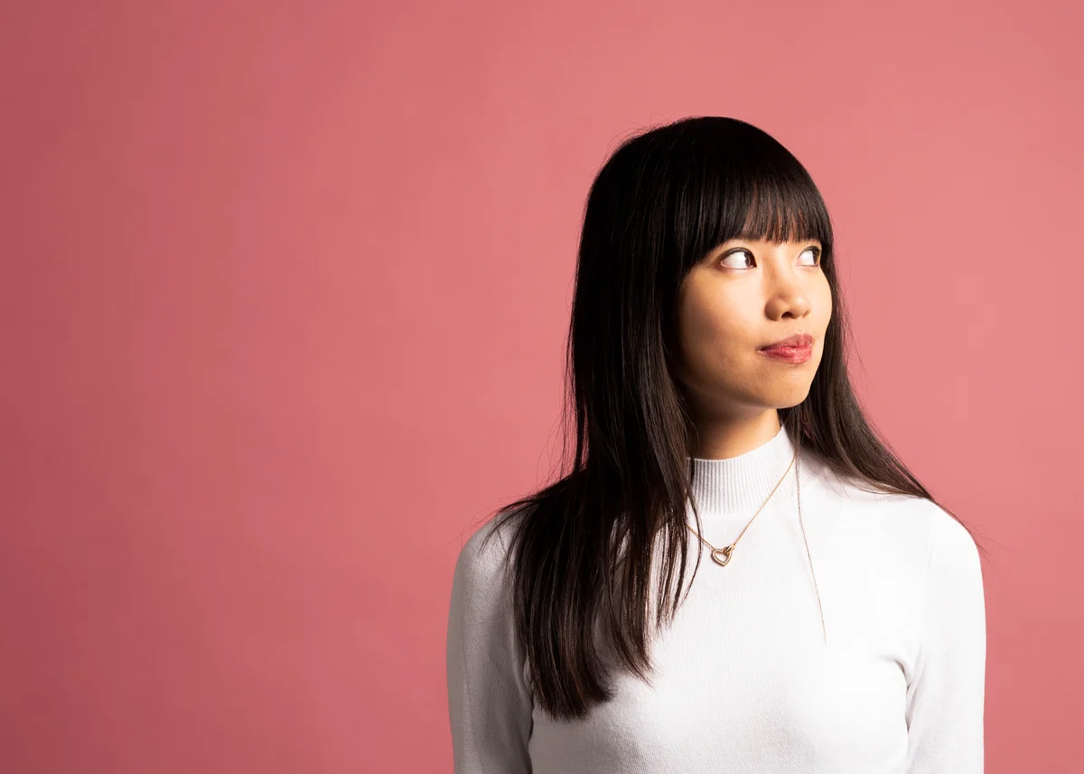 portrait of a woman against a pink background