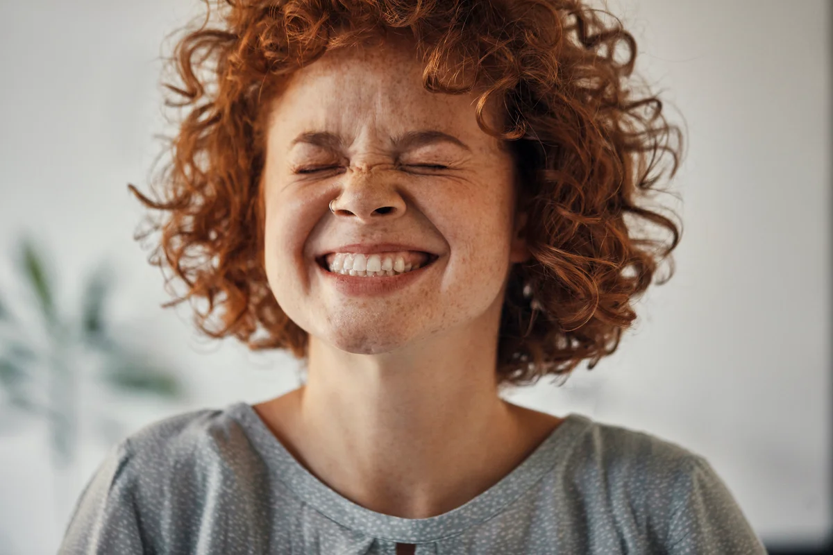 woman smiling with eyes closed
