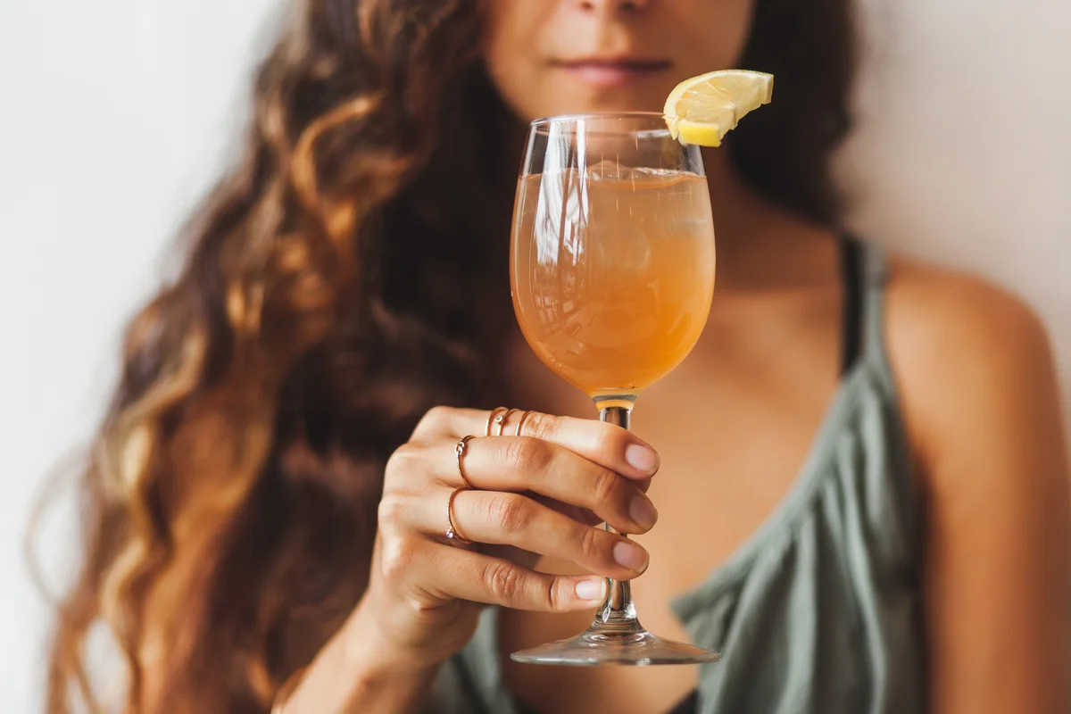 woman holding glass with tasty and cold drink