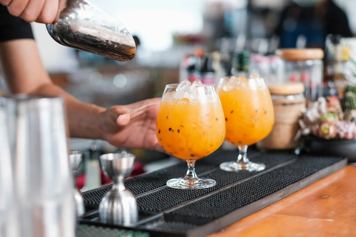 Close up of freshly prepared cocktails in a row outdoors on a bar counter