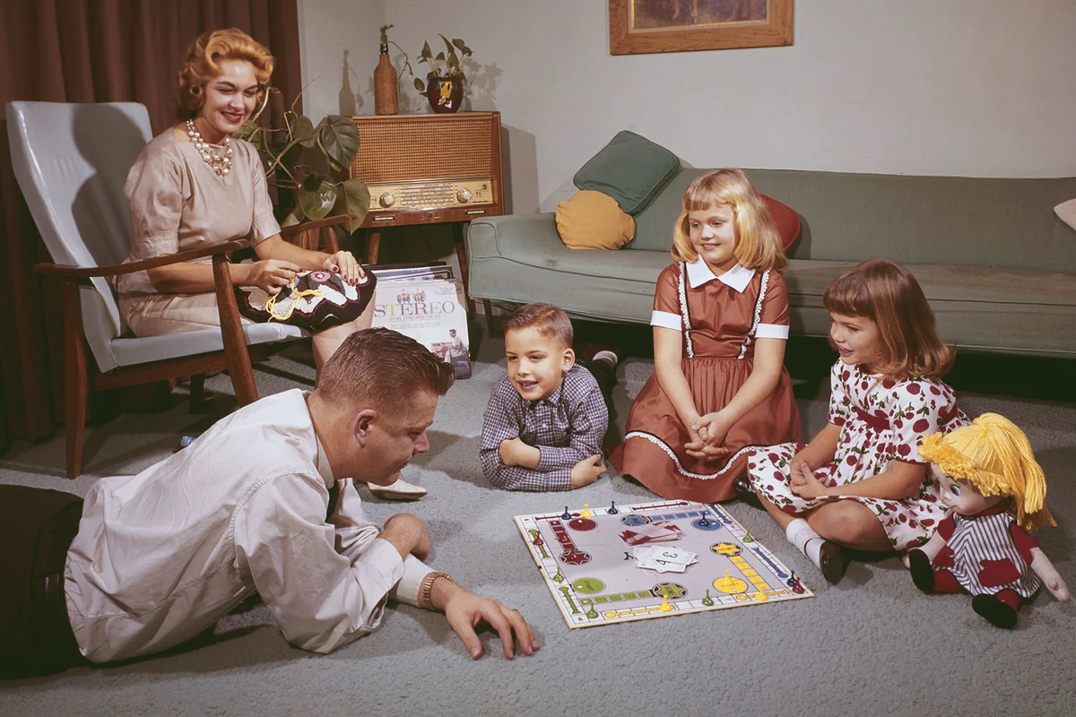 A young family playing ludo with their dad while the mother crochets, 1962