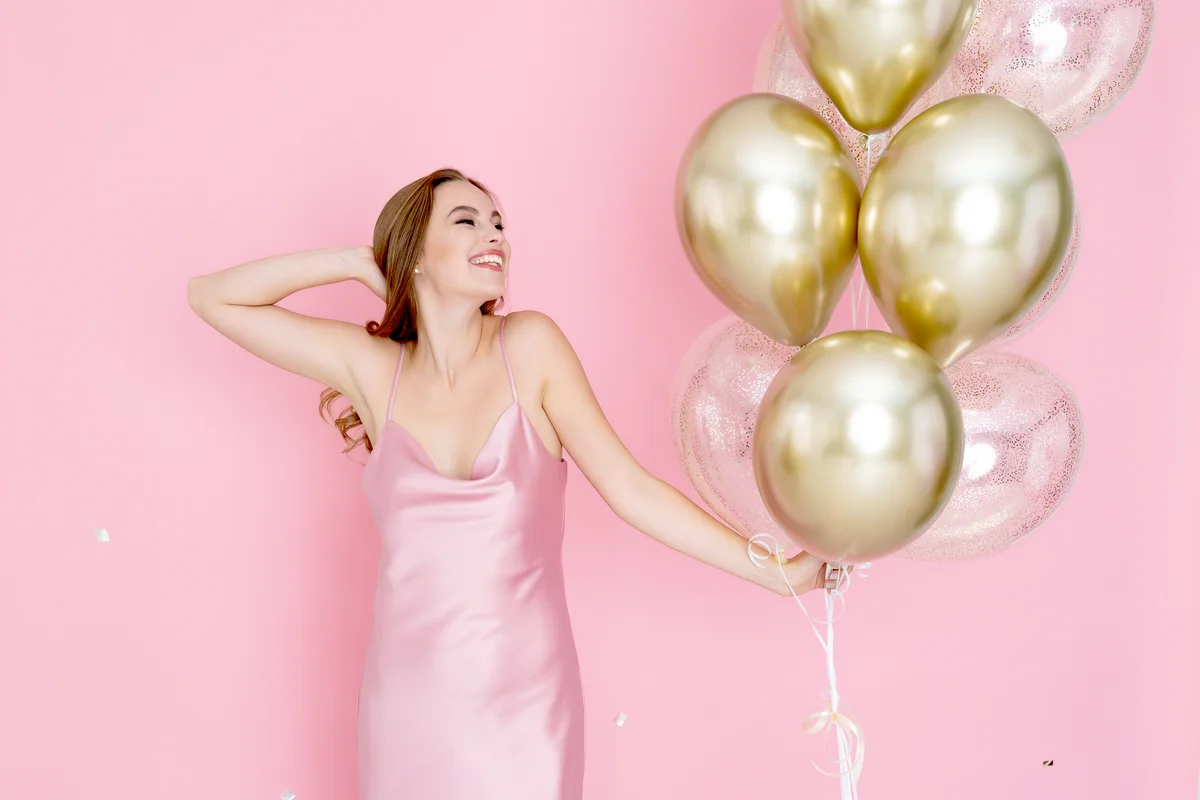 Woman in pink dress with balloons