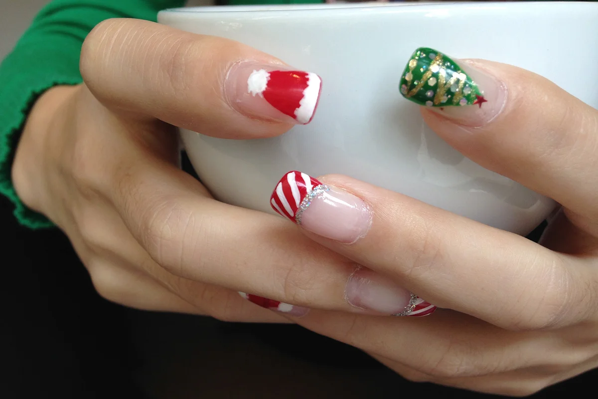 Christmas nails holding a coffee cup