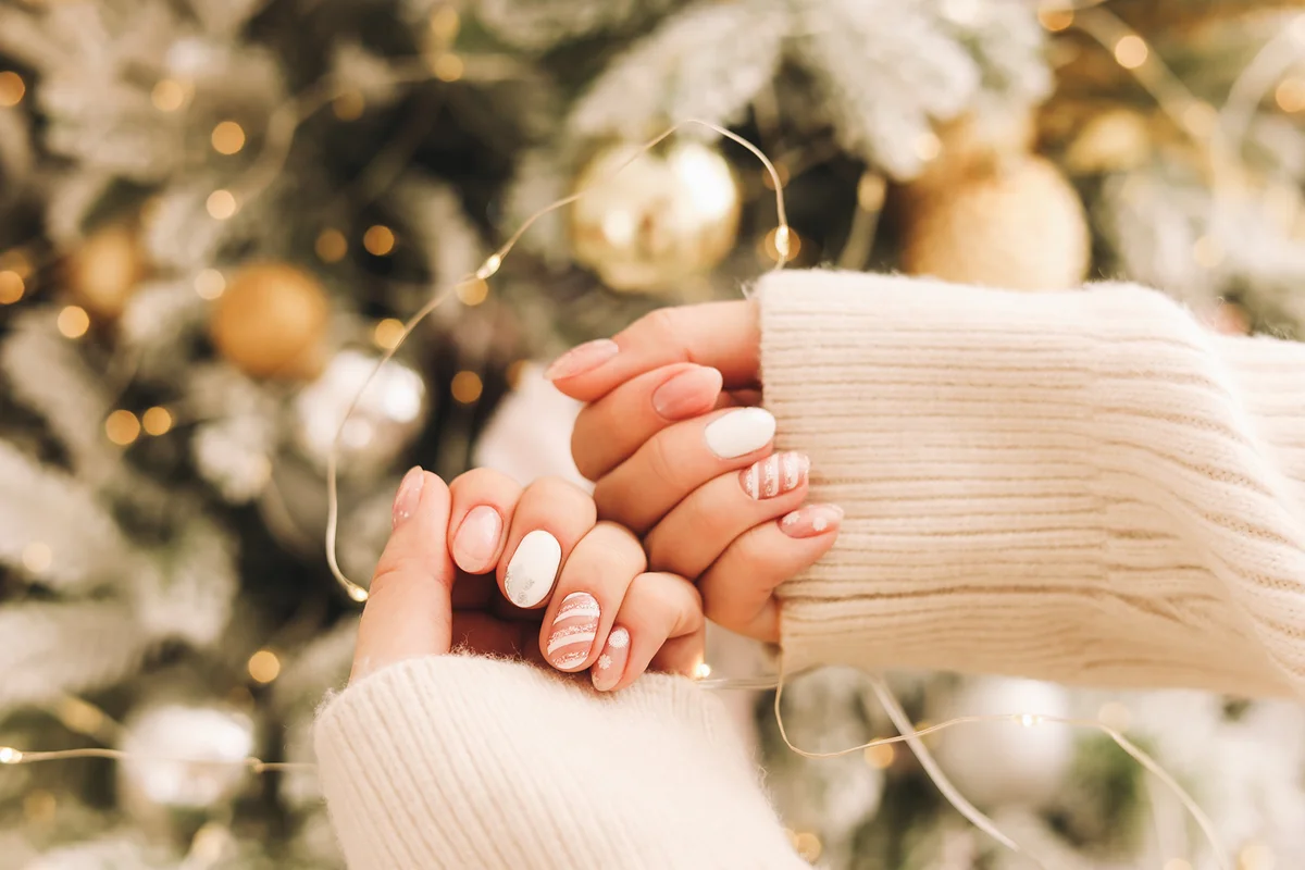 Women's hands with a well-groomed manicure in a cozy sweater
