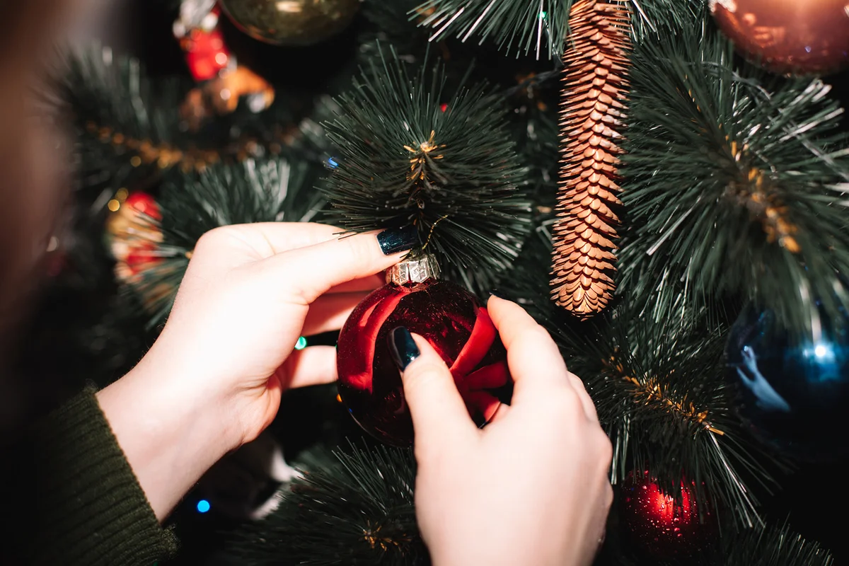 Young woman decorating Christmas tree