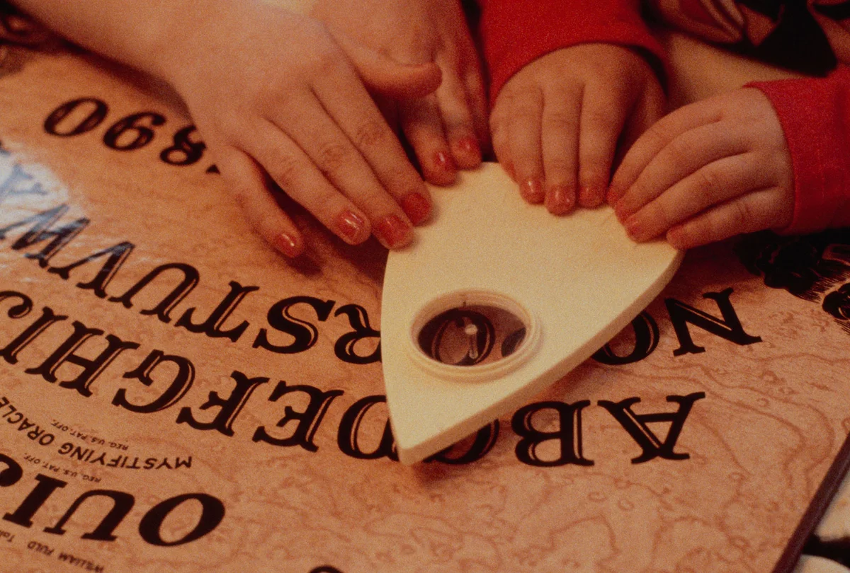 Children play with Ouija board