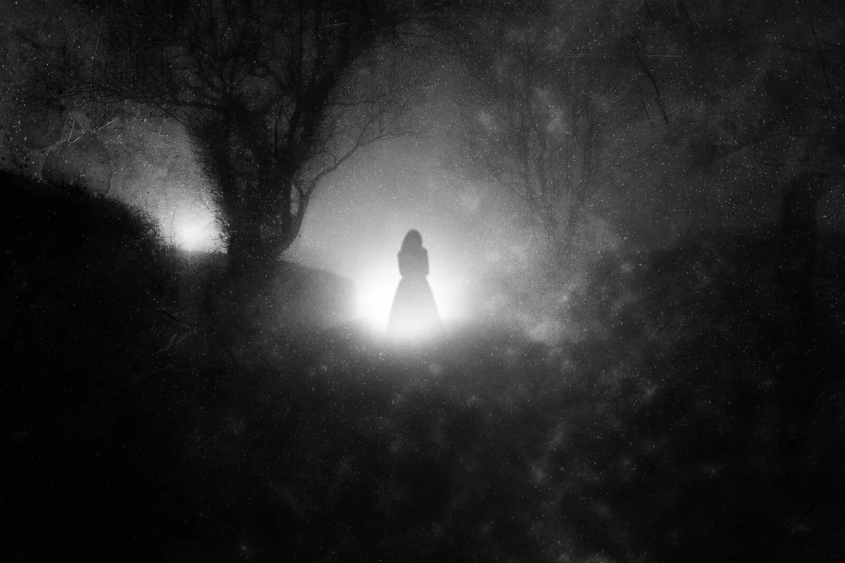 A country lane, on a foggy night with a ghostly woman in a dress