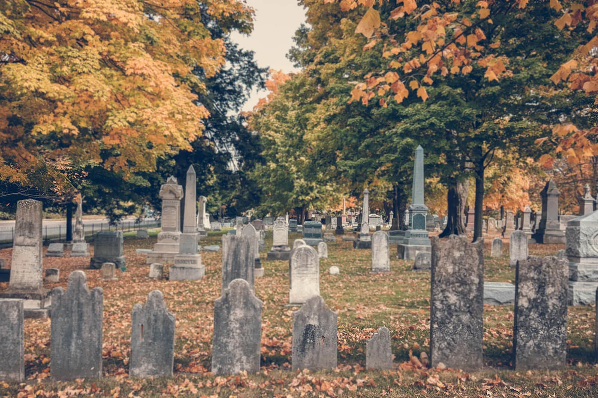 Tombstones At Cemetery During Autumn