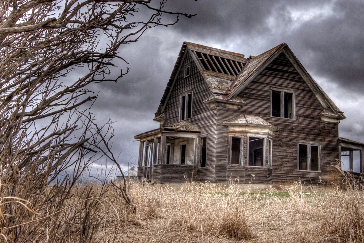 Abandoned house against cloudy sky