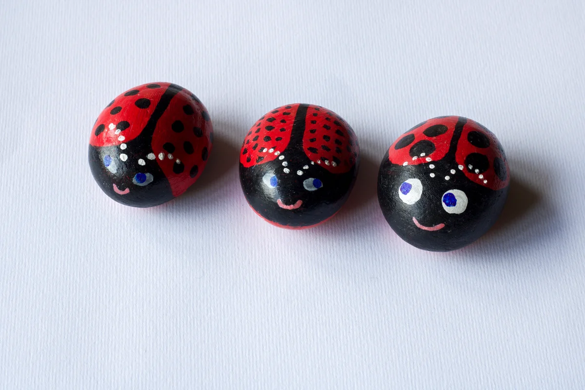 Close up of three painted stones as cute ladybugs