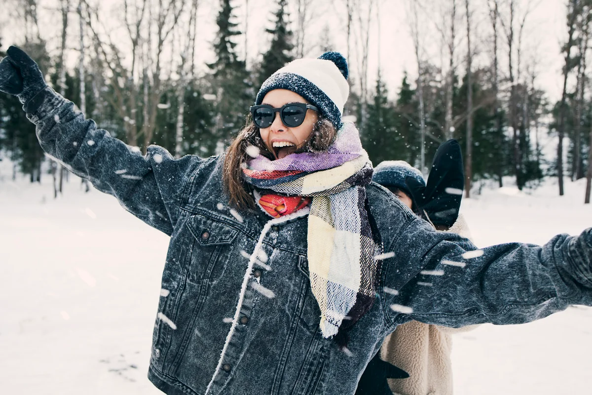 Happy woman enjoying with friend at snowy field