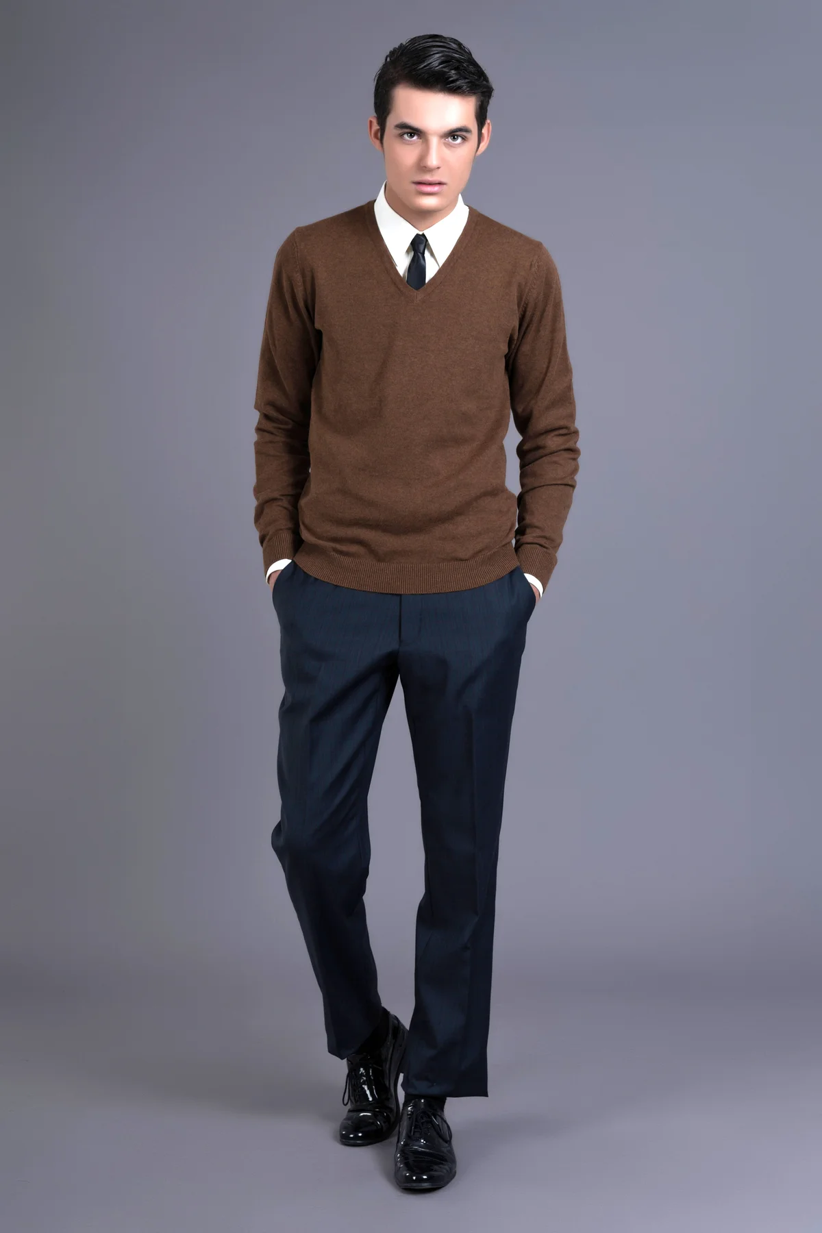 Man wearing brown sweater with black tie