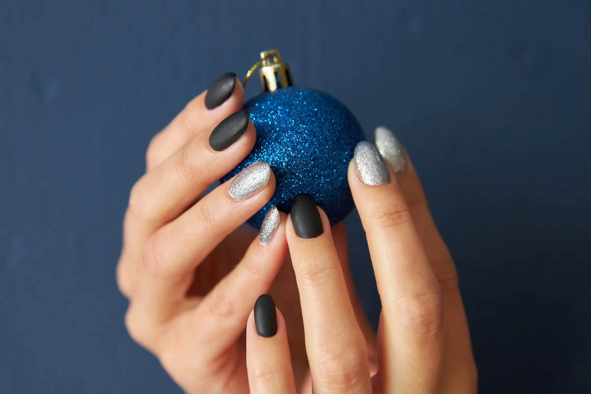 Female hands hold ball Christmas tree toy on blue background