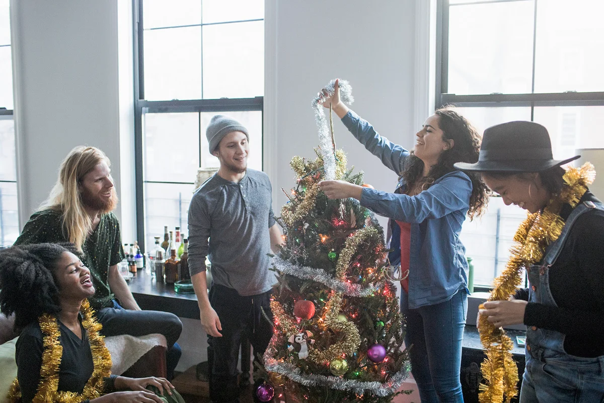 A group of people decorating a Christmas tree