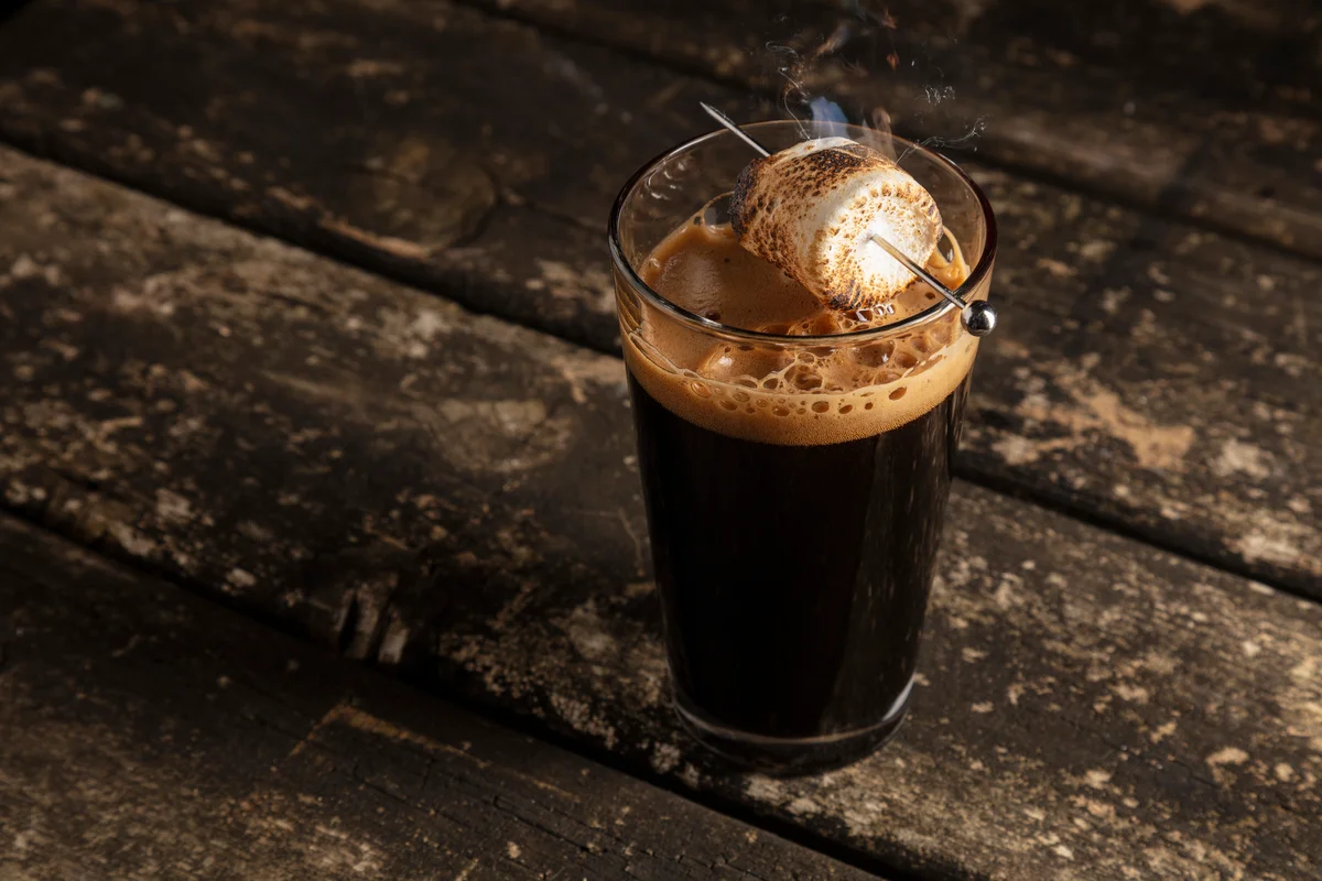 dark porter beer on wood table with a roasting marshmallow
