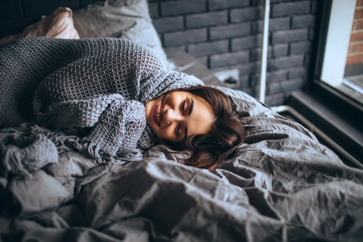 Young woman in cozy bed