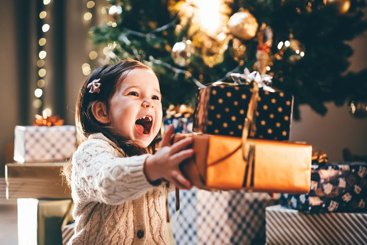 Lovely little girl receiving a Christmas gift