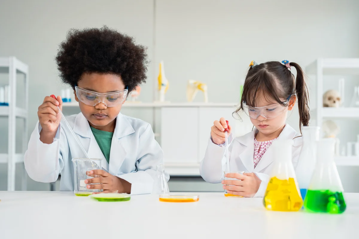 Young boy and girl enjoy science experiment in laboratory at school