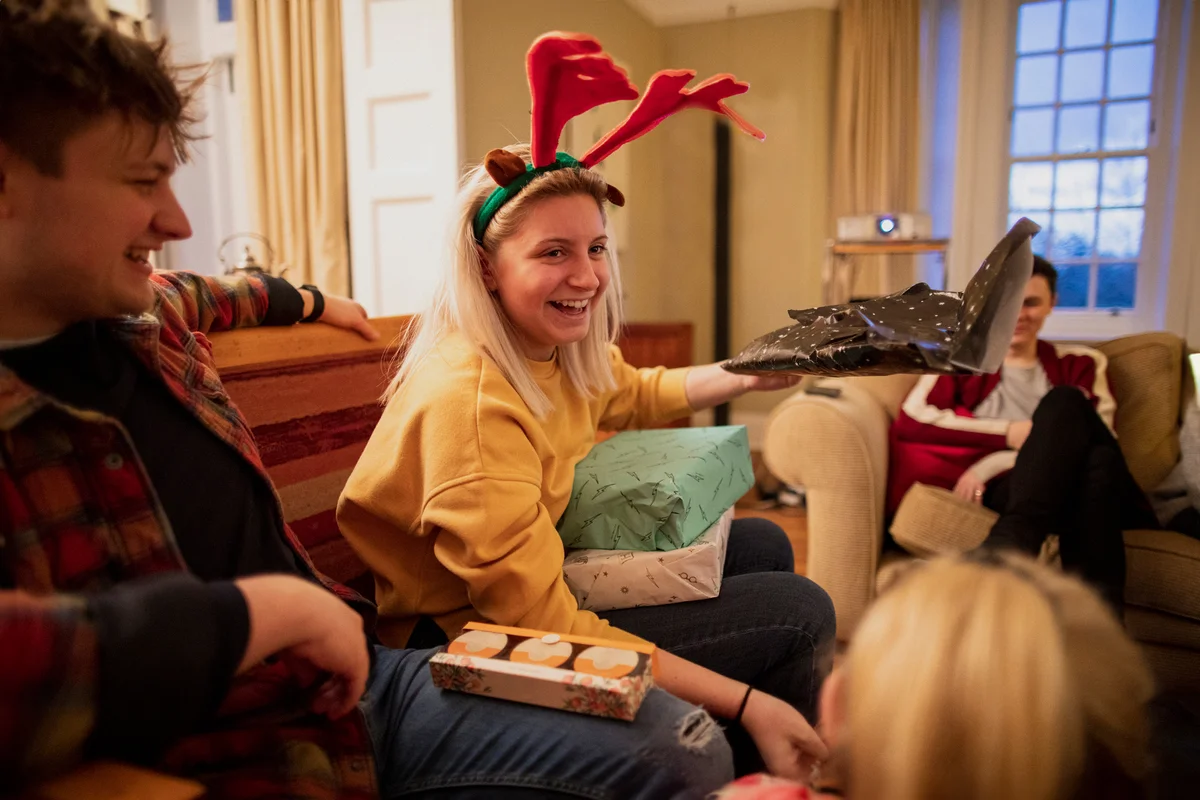 Young people are sitting together in the living room at a house party