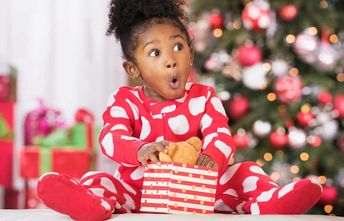 Surprised girl holding teddy bear toy on Christmas