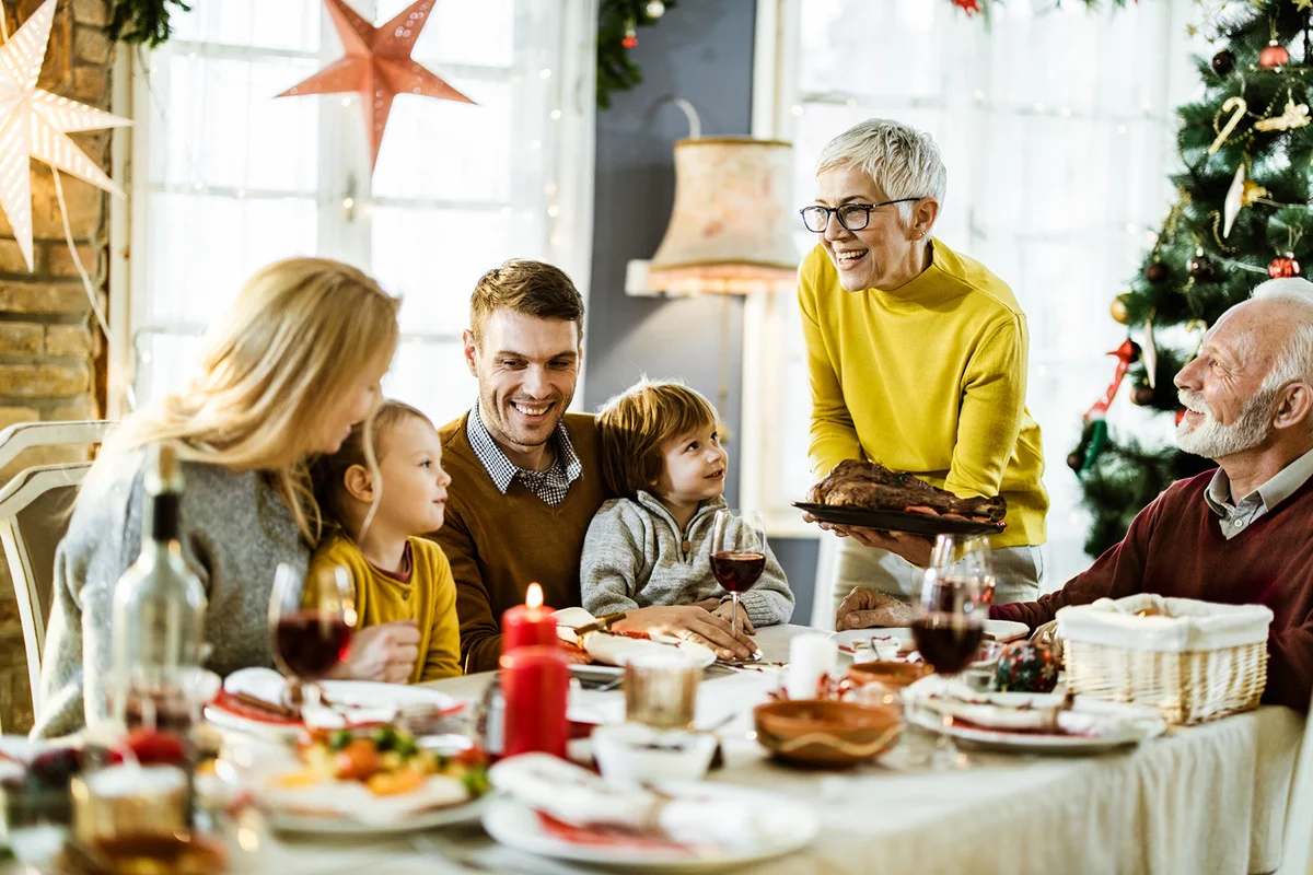 Happy senior woman serving food to her family on Christmas