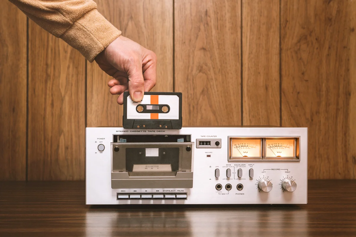 Man inserts cassette in retro tape player