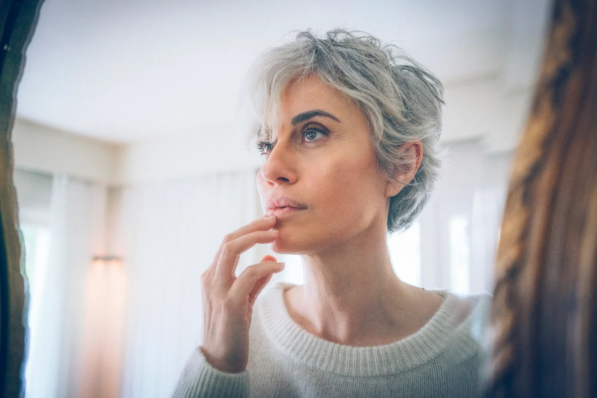 Gray haired woman by the mirror