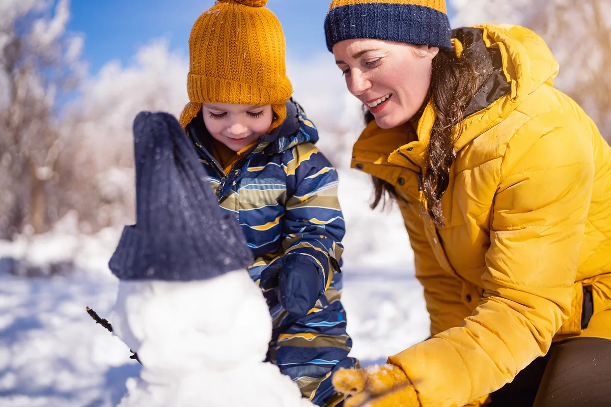 Mom and son making a snowman together