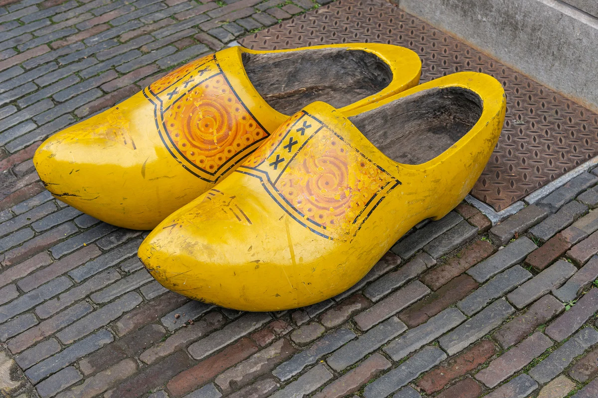 Two large yellow Dutch clogs placed outside on the street