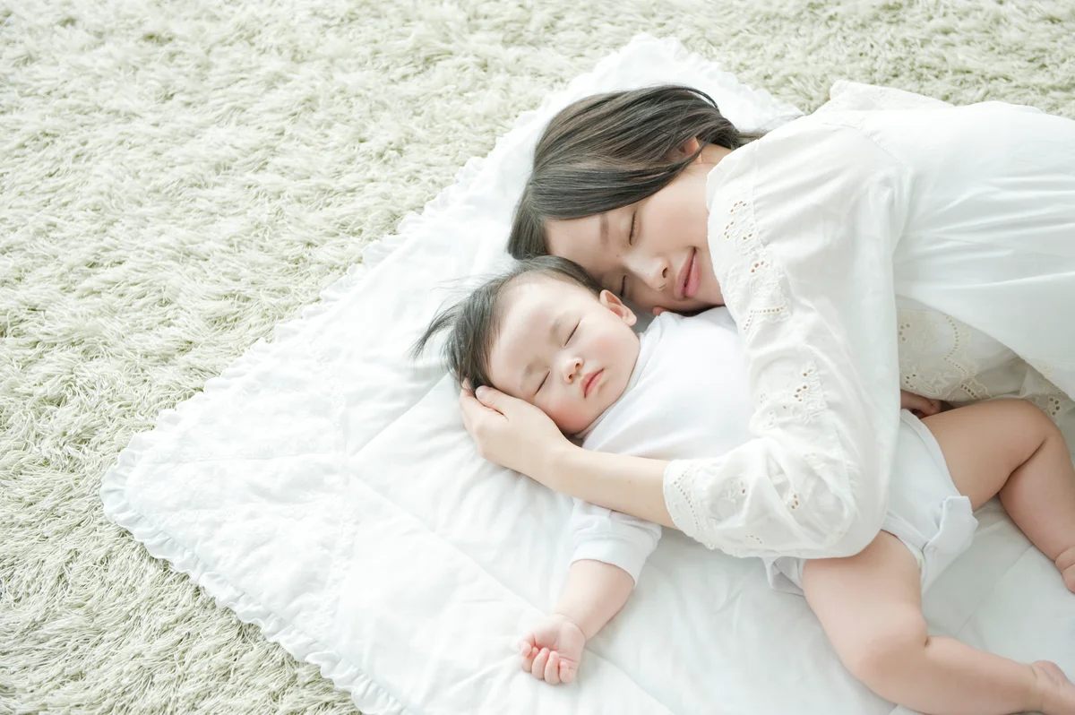 Mother and baby girl sleeping together