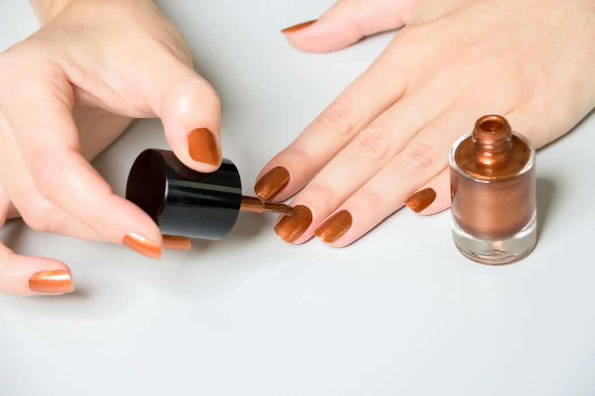 Woman Applying Bronze Polish to Nails
