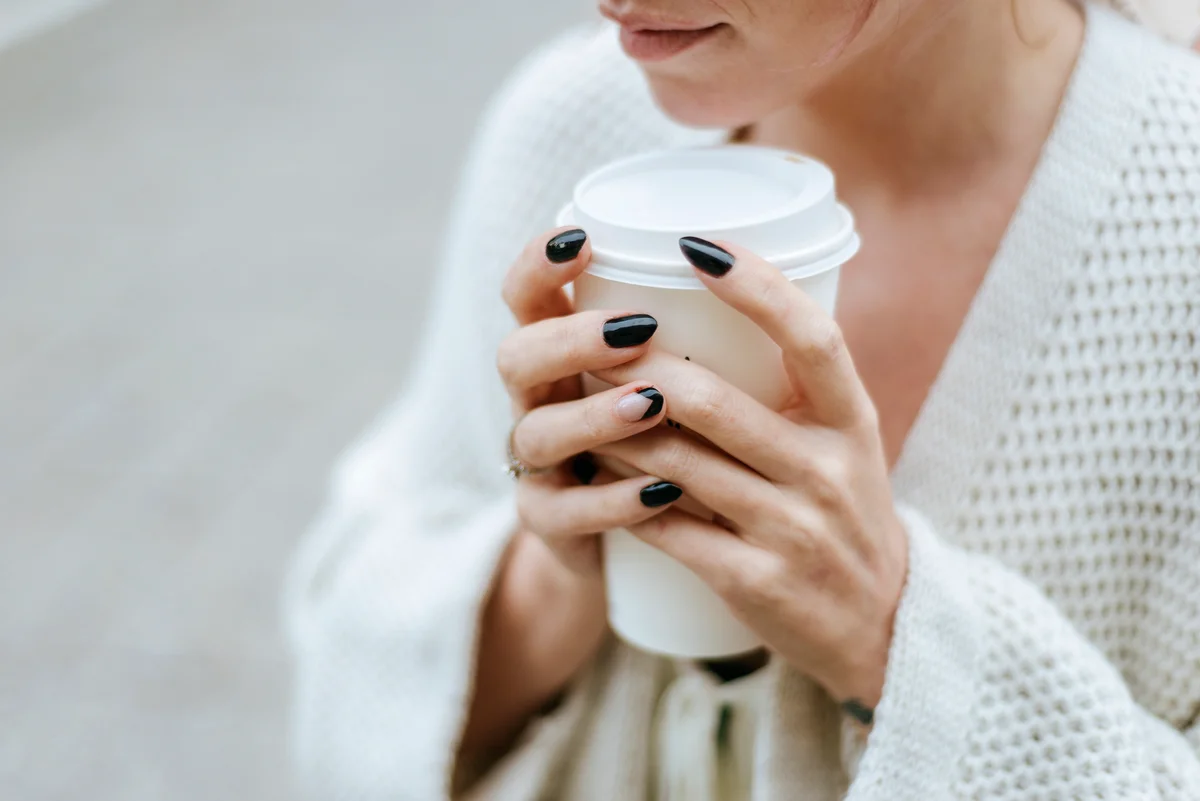 Close-up of woman's hands with take away drink