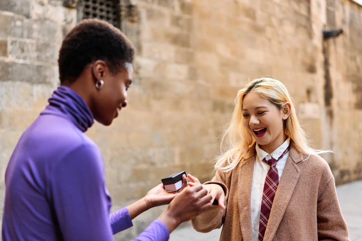 Woman putting a ring on the finger of her couple