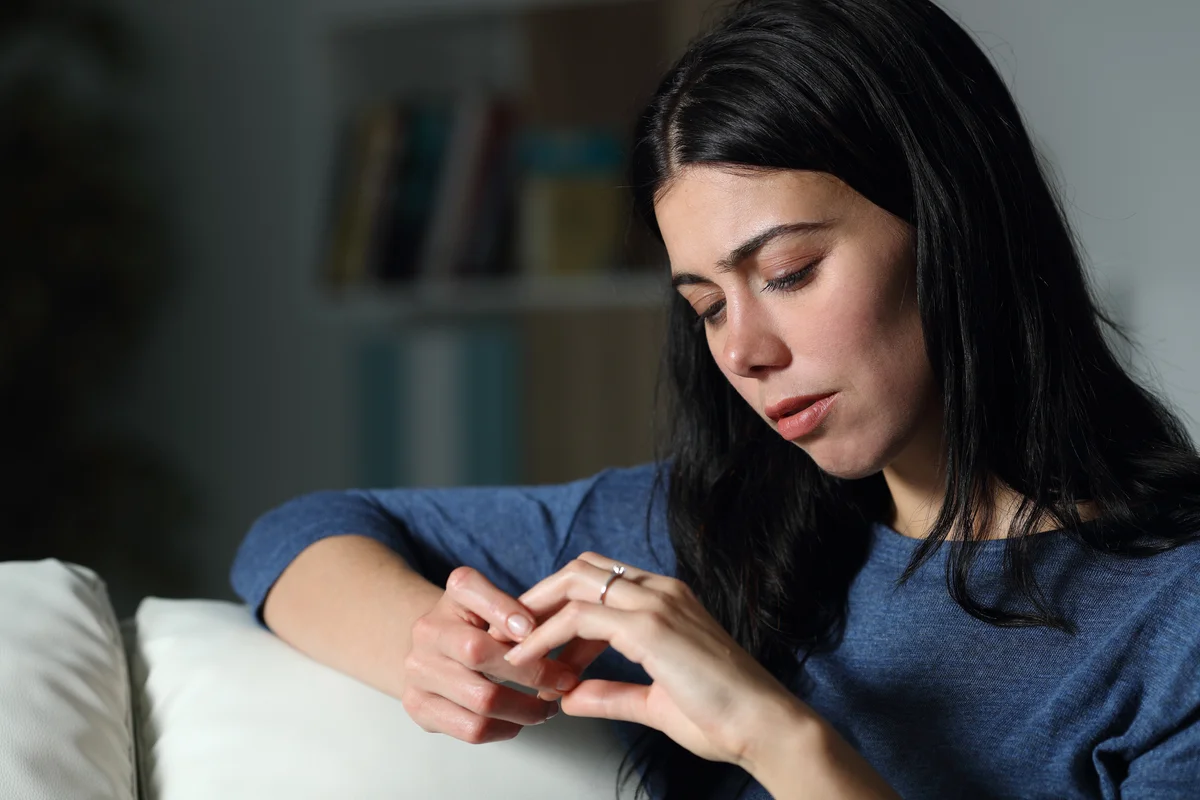 Confused woman looking at engagement ring
