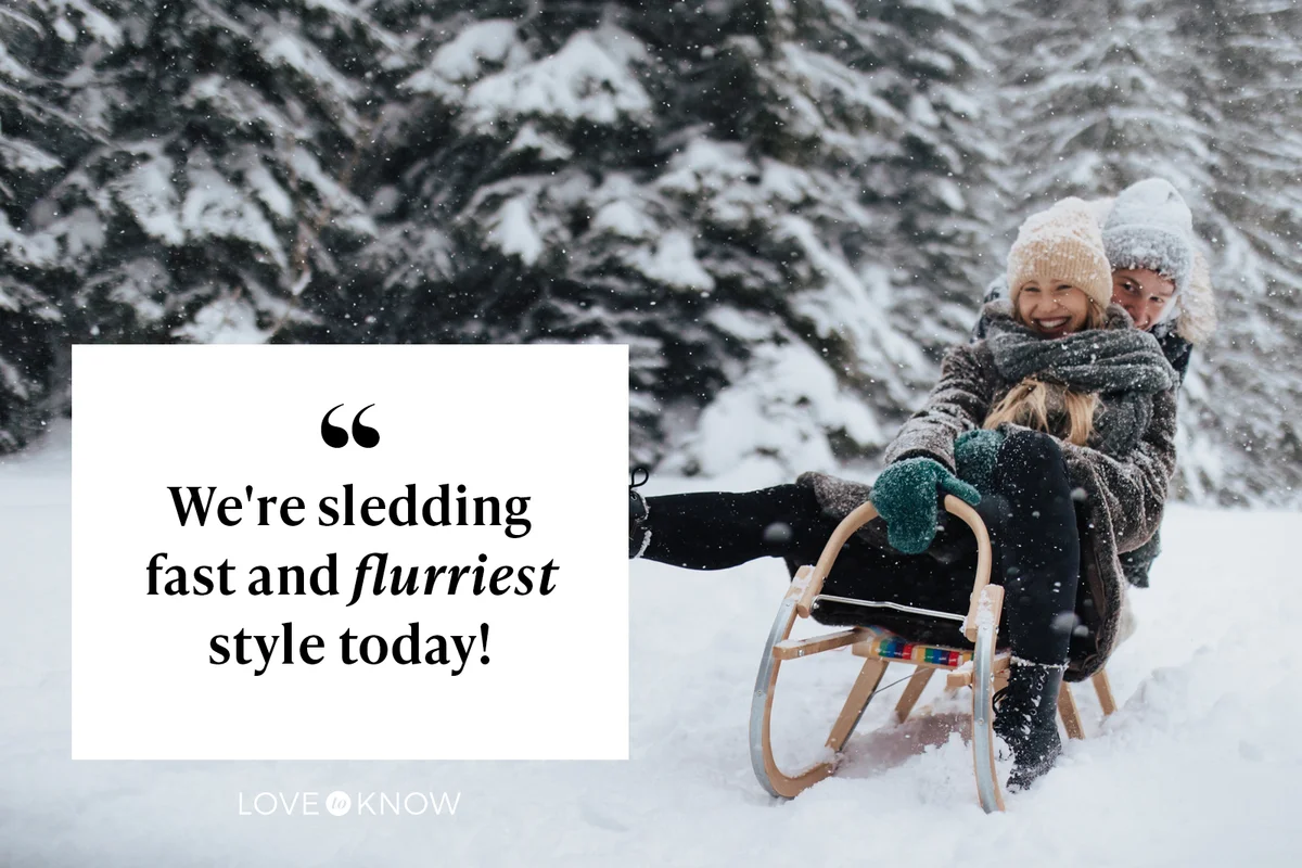 Young couple sledding in wintery nature under falling snow