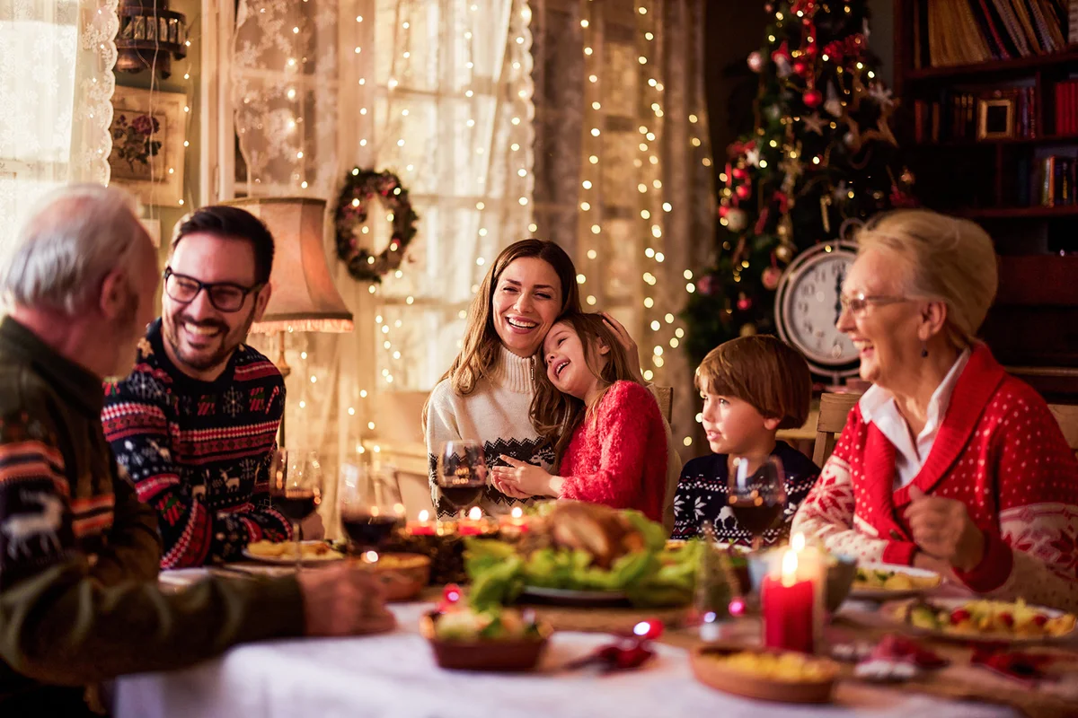 Cheerful extended family talking during Christmas dinner at home