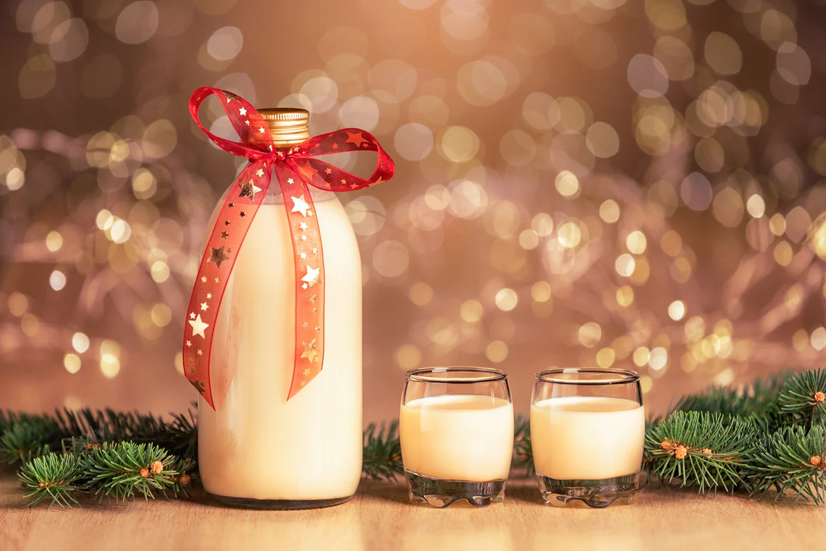 Bottle of homemade eggnog with two glasses