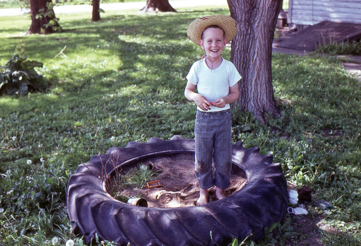 boy in a tire sandbox