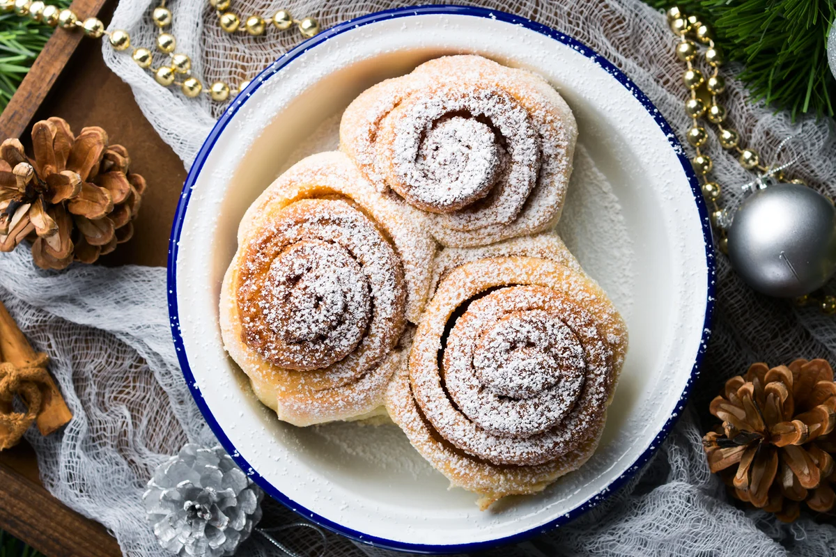 Cinnamon roll buns in enamel bowl with Christmas decorations