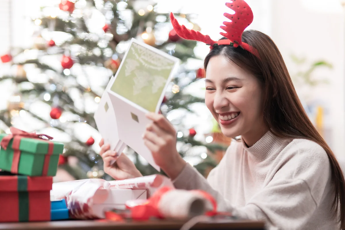 woman reading Christmas greeting card
