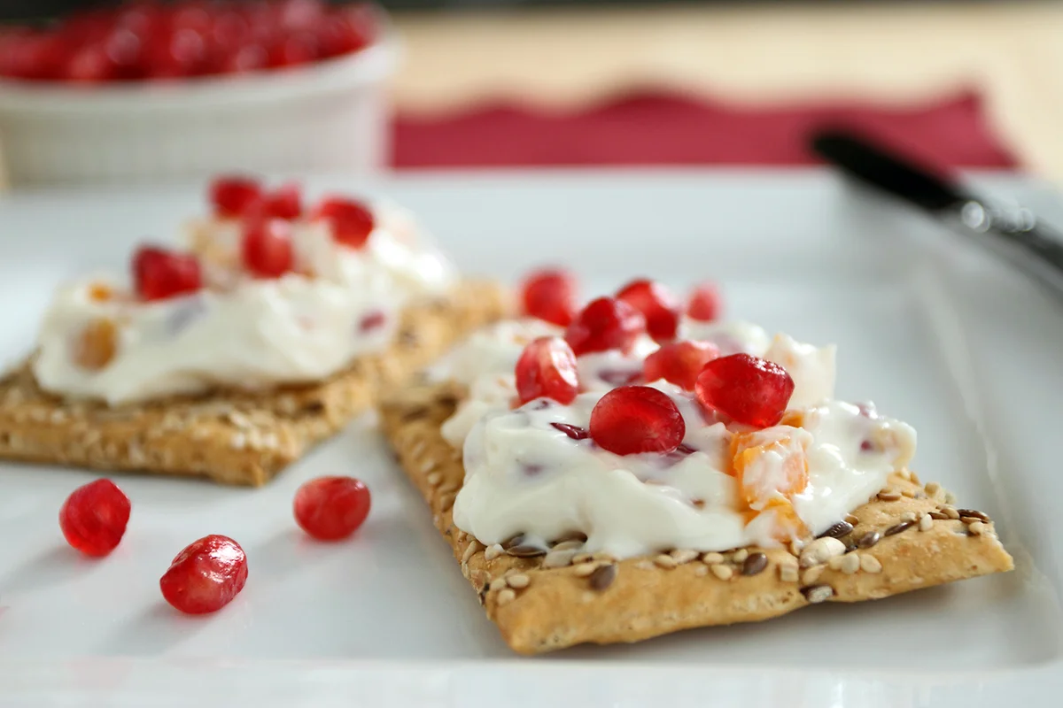 Apricot and pomegranate cream cheese spread on crackers.