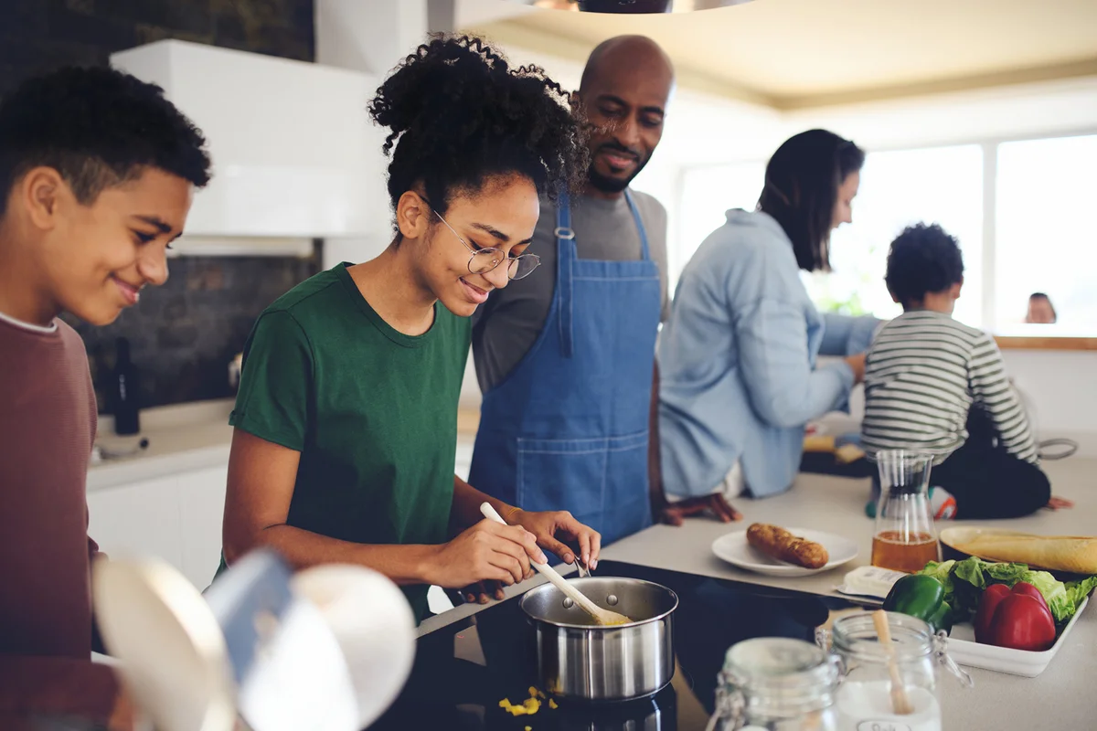 Family with three children cooking together at home