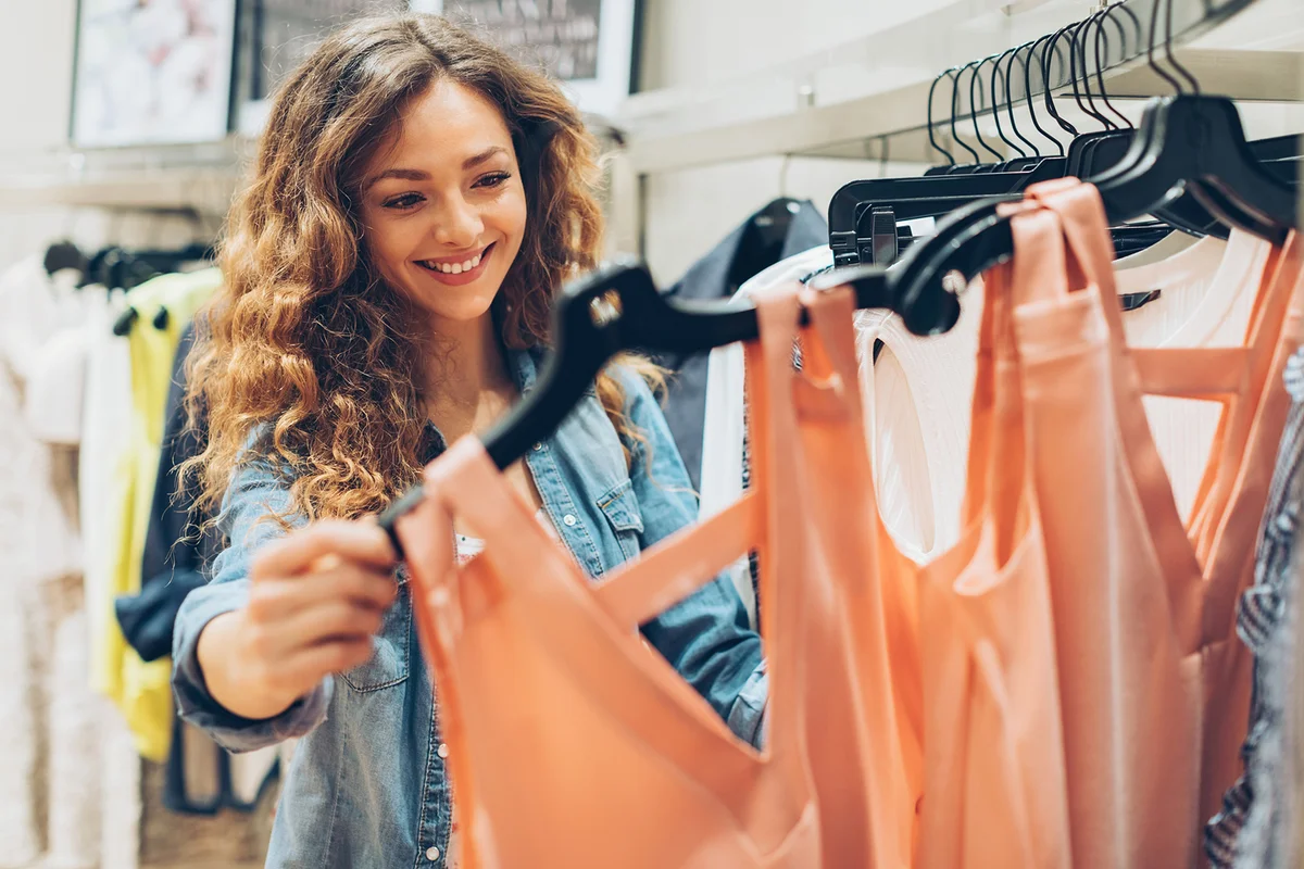 Beautiful young woman looking around in the fashion department store