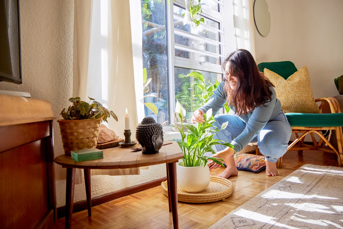 Full length shot of an attractive young woman rearranging her living room at home