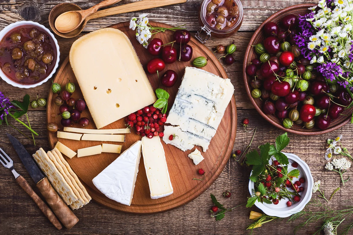 Cheese platter with fresh colorful summer berries