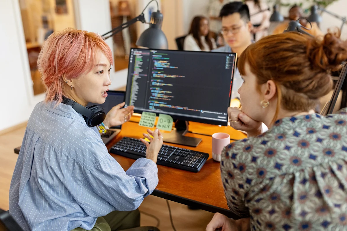 Creative businesswomen discuss over new coding program