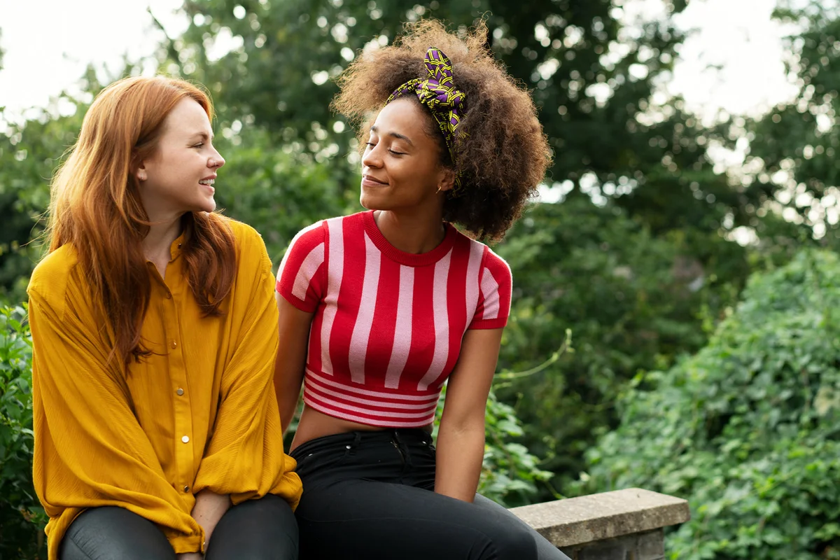 Two women sat on wall